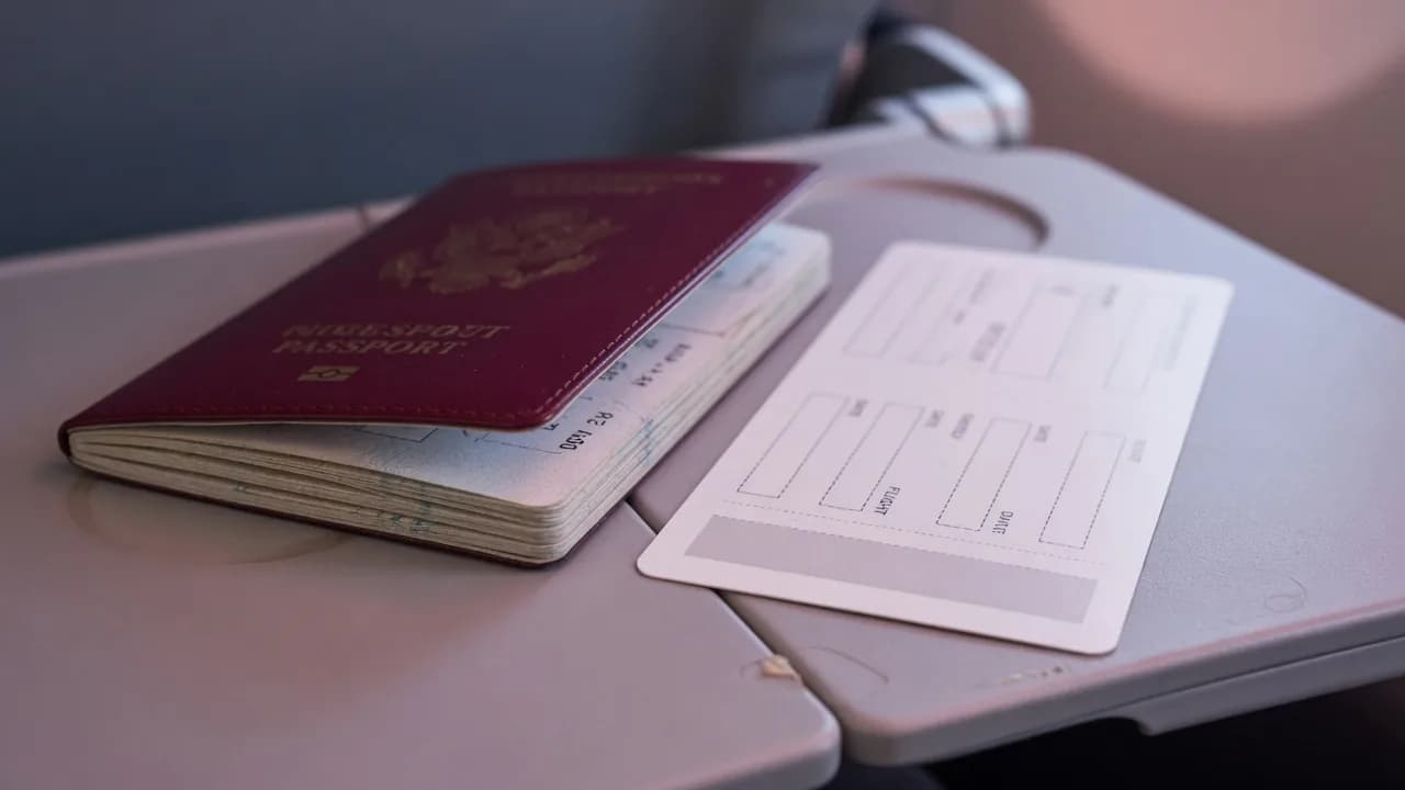 Passport and blank boarding card on an aircraft tray table